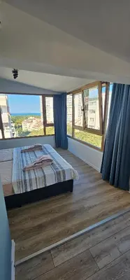 a bedroom with a bed and a large window at Studio Nikol in Burgas City