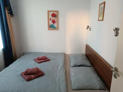a bedroom with a bed with two red pillows on it at Sunny Beach Apartment, Kokiche Hotel - white building Liliya in Sunny Beach