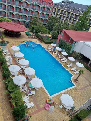 a swimming pool with umbrellas and chairs and a hotel at Sunny Beach Apartment, Kokiche Hotel - white building Liliya in Sunny Beach