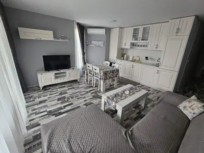a living room with a couch and a tv at Denevi' seaside apartment - 2 bedrooms in Lozenets