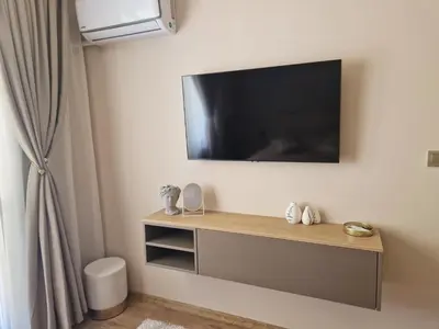 a living room with a tv on the wall at Delux Apart Vulchevi with Parking in Burgas City