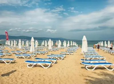 a bunch of beach chairs and umbrellas on a beach at Messembria Resort in Nesebar