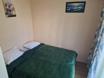 a small bedroom with a green bed in the corner at Messembria Resort in Nesebar