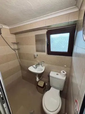 a small bathroom with a toilet and a sink at Вила 50 in Atiya