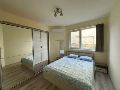 a bedroom with a bed and a large window at Ssenyange Sea View Apartment in Varna City