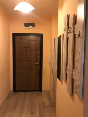 a hallway with a door in a room with wooden floors at Ssenyange Sea View Apartment in Varna City