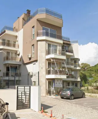 a building with a car parked in front of it at Ssenyange Sea View Apartment in Varna City