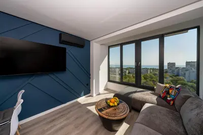 a living room with a couch and a large window at Lazur Sea View in Burgas City