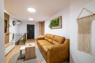 a living room with a brown leather couch at Angel Home 2bdrm Modern Apartment in Varna City