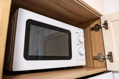 a microwave oven on a shelf in a kitchen at Angel Home 2bdrm Modern Apartment in Varna City
