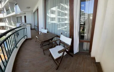 a balcony with chairs and a table on a building at Private apartments Ravda-Emerald in Ravda