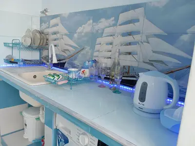 a kitchen with a sink and a pirate ship on the wall at Apartament ALBATROS in Burgas City