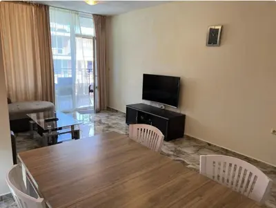 a living room with a table and a television at Karolina complex appartment in Sunny Beach