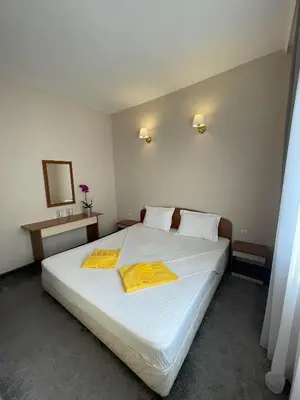 a bedroom with a white bed with yellow towels on it at Alatoni Beach Hotel in Sozopol
