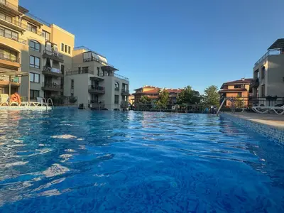 a swimming pool with blue water in front of buildings at Sorrento Sole Mare Studio Appartment in Sveti Vlas
