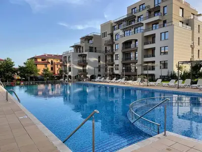 a large swimming pool with chairs and buildings at Sorrento Sole Mare Studio Appartment in Sveti Vlas