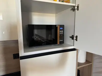 a kitchen with a microwave in a white cabinet at Sorrento Sole Mare Studio Appartment in Sveti Vlas