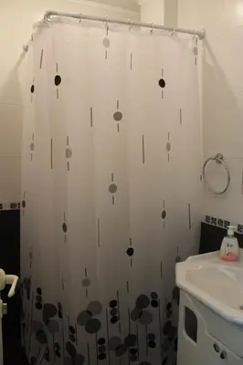 a bathroom with a shower curtain with black and white dots at Stela Guest House in Tsarevo