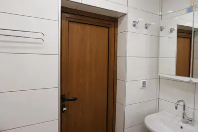 a bathroom with a wooden door and a sink at Azur Holiday Burgas - self check-in in Burgas City