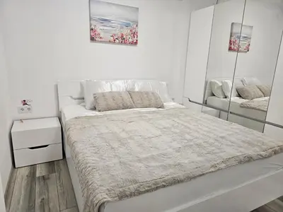a white bedroom with a large bed and mirrors at Ann's apartment in Varna City