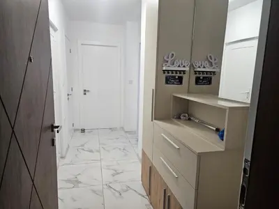 a kitchen with a white tile floor and white cabinets at Ann's apartment in Varna City
