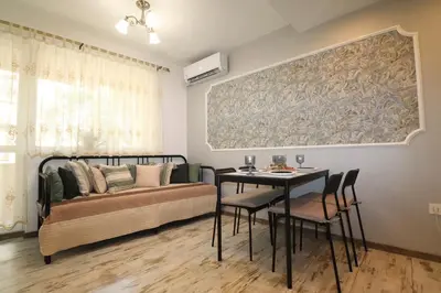 a bedroom with a bed and a table with chairs at Relax apartment with parking in Varna City