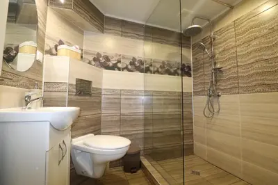 a bathroom with a toilet and a glass shower at Relax apartment with parking in Varna City