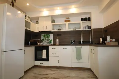 a kitchen with white cabinets and a white refrigerator at Relax apartment with parking in Varna City