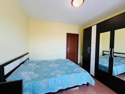 a bedroom with a bed with a blue comforter at AMADEUS I B31 Apartment Sunny Beach in Sunny Beach