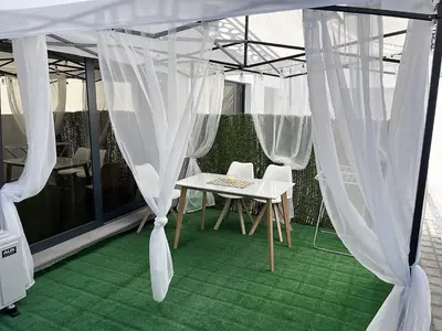 a white tent with a table and chairs under it at Студио Морски дни-топ локация в Созопол in Sozopol