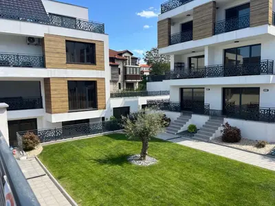 an apartment building with a lawn in front of it at Студио Морски дни-топ локация в Созопол in Sozopol