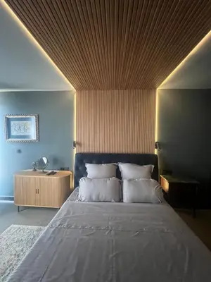 a bedroom with a large bed with a wooden ceiling at Apartament Panorama in Pomorie