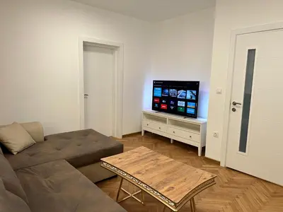 a living room with a couch and a flat screen tv at Romantic City Central Apartment in Varna City