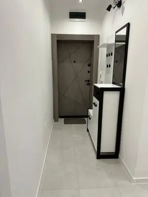 a hallway with a door and a kitchen with a mirror at Romantic City Central Apartment in Varna City