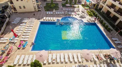 an overhead view of a swimming pool with chairs and umbrellas at Sunny Beach Victoria Penthouse in Sunny Beach