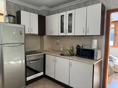 a kitchen with white cabinets and a stainless steel refrigerator at Niko's Apartment in Sozopol