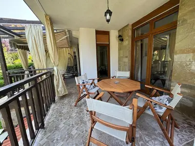a patio with a wooden table and chairs on a balcony at Niko's Apartment in Sozopol