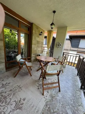 a dining room with a table and chairs on a balcony at Niko's Apartment in Sozopol