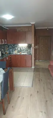 a large kitchen with wooden cabinets and a door at Marina bay in Sveti Vlas