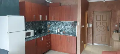 a kitchen with wooden cabinets and a white refrigerator at Marina bay in Sveti Vlas