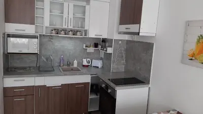 a kitchen with white cabinets and a sink at Apartament Diana in Pomorie