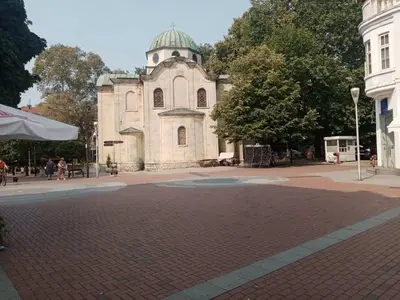 a building with a clock tower on a brick road at Apartment Black Sea Center 1 in Varna City