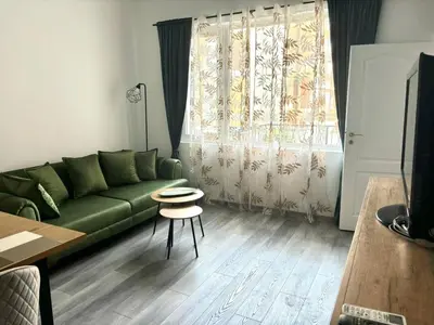 a living room with a green couch and a table at Apartment Black Sea Center 1 in Varna City