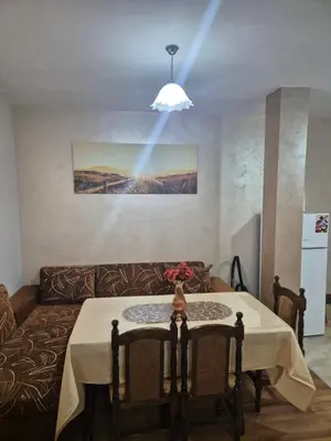 a living room with a table and a couch at Делукс Апарт Вергиеви in Burgas City