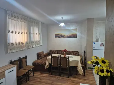 a living room with a table and a couch at Делукс Апарт Вергиеви in Burgas City