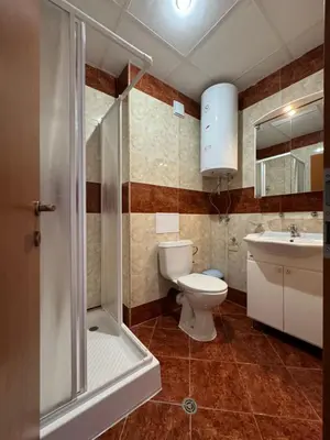 a bathroom with a shower and a toilet and a sink at Fort Noks Panorama in Elenite