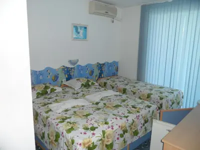 a bedroom with a bed with flowers on it at Sianie Guest House in Ravda