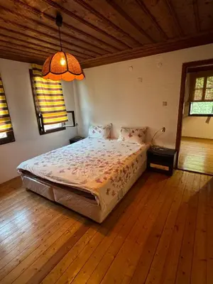 a bedroom with a bed and a chandelier at Вила Мила in Tsarevo