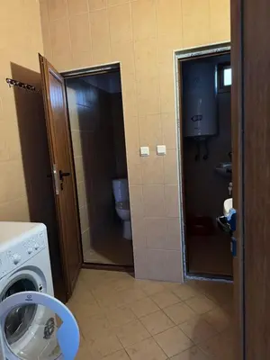 a bathroom with a washing machine and a toilet at Вила Мила in Tsarevo