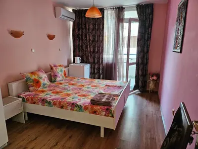 a bedroom with a bed in a room with pink walls at Стая за гости на Бургас 1 in Burgas City